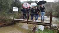 Puentecillo de entrada al Parque Nacional de Cabañeros con visitantes en día de lluvia.