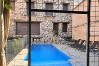 Fachada trasera, piscina y solárium de la casa rural La Fuente Gorda, en Navas de Estena, en el Parque Nacional de Cabañeros.