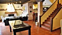 Salón de 80 m2 de La Fuente Gorda con, desde la izquierda, mesa expositora, chimenea, cocina, comedor y zona TV (fuera de campo)