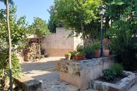 Patio de La Fuente Gorda, casa rural en Cabañeros. Leñera al fondo.