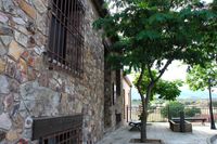 Fachada principal de la casa rural La Fuente Gorda, en Navas de Estena. A la derecha, fuente de granito que da nombre a la casa.