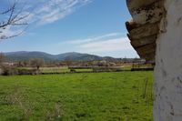 Construcción tradicional de piedra encalada y prados alrededor de Navas de Estena. Sierras de los Montes de Toledo al fondo. Construcción tradicional de piedra encalada y prados alrededor de Navas de Estena. Sierras de los Montes de Toledo al fondo.