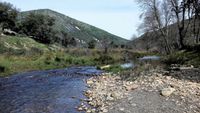 Río Estena aguas arriba del puente, camino de las Fuentes. Al fondo, la sierra de Majalaburra recuperada de su incendio en 2012.